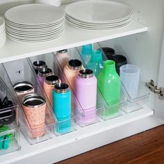 there are many cups and plates on the shelf