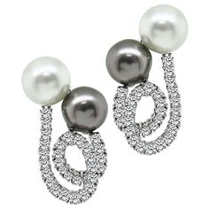 This is a stunning pair of 18k white gold and platinum earrings. The earrings feature sparkling round cut diamonds that weigh approximately 3.70ct. The color of these diamonds is E-F with VS clarity. The diamonds are accentuated by lovely white and grey south se pearls. The earrings measure 36mm by 30mm and weigh 28.2 grams. The earrings are stamped 18K PT900. Inventory #15217AOSS South Sea Pearls Earrings, Platinum Earrings, Sea Pearl, South Sea Pearls, Sea Pearls, Round Cut Diamond, Round Cut, Platinum, Pearl Earrings