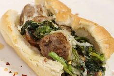 a meatball sub sandwich with broccoli and onions