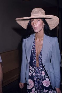 a woman wearing a large hat and dress