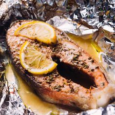 fish with lemon slices and herbs on foil