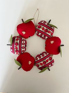 four apple ornaments are arranged in a circle