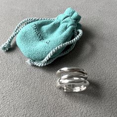 a blue bag sitting on top of a gray floor next to a metal object with rope wrapped around it