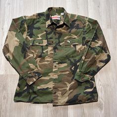 a camo shirt sitting on top of a wooden floor