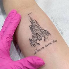 a woman's leg with a tattoo on it that says dream come true and mickey mouse