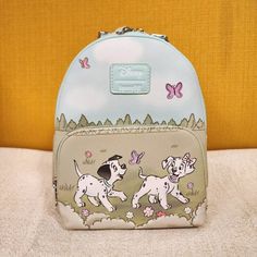 These 101 Dalmatians Pups Are Ready For Springtime! This Mini Backpack Shows The Two Pups Strolling In A Flower Field, With Butterflies In The Air. Front Zippered Pocket, Interior Pocket And Adjustable Straps. * * * * Features * * * * * Height 10" * Width 5.5" * Length 8" * Top Handle 3" * Adjustable Straps * Zip Closure * Silver Hardware * Faux Leather Exterior * 1 Front Zip Pocket * Interior Is Light Purple Cloth * Inside Has 1 Pouch * By Loungefly & Disney * New With Tags Make This Cute Bag Y Purple Cloth, Disney Adult, Disney 101 Dalmatians, Loungefly Bag, Old Disney, Loungefly Disney, 101 Dalmatians, Disney Merchandise, Flower Field