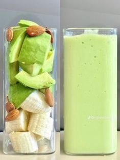 a glass filled with green liquid next to a container full of bananas and other fruit