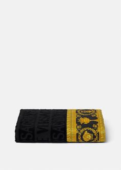 a black and yellow towel with an embroidered dragon on it's side, in front of a white background