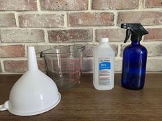 a table topped with bottles and containers next to a brick wall