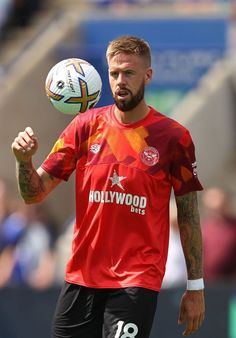 a man holding a soccer ball in his right hand