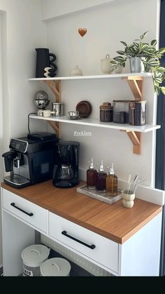 a kitchen counter with coffee maker, cups and other items on it's shelves