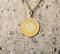 Embrace the mystique with this stunning  pendant necklace, featuring an intricate design of a radiant sun encircling an all-seeing eye. Crafted with meticulous attention to detail, this piece exudes a timeless elegance, perfect for adding a touch of celestial charm to any outfit. The pendant hangs gracefully on a durable chain, making it a versatile accessory for both casual and formal occasions. Elevate your jewelry collection with this unique and captivating sun and eye pendant necklace. - Mat Spiritual Sun Design Jewelry, Symbolic Gold Jewelry With Sun Design, Spiritual Round Necklaces With Sun Design, Spiritual Sun Design Pendant Jewelry, Symbolic Round Sun Design Necklace, Symbolic Sun Design Round Necklace, Spiritual Sun Design Round Necklaces, Gold Spiritual Necklace With Sun Design, Symbolic Jewelry With Sun Design Round Pendant