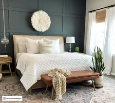 a bedroom with a large bed and white comforter on top of it, next to a window