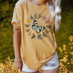 👀Images are an accurate depiction of what you'll receive upon purchase ♂️ All Shirts are Unisex Sizing 👣 Printing is "Direct To Garment"  (Ink printed). 🦋 Step into the serene beauty of a summer meadow with our "Dance of the Butterflies" tee, a harmonious blend of cottagecore charm and boho allure. Delicately crafted, it features a majestic butterfly at its center, encircled by a wreath of fluttering companions, all woven together with subtle vines. This design exudes a tranquil mood, invitin Cotton Multicolor Tops With Butterfly Print, Summer Cotton Shirt With Butterfly Print, Short Sleeve Cotton Tops With Butterfly Print, Cotton Tops With Butterfly Print And Short Sleeves, Spring Butterfly Print Crew Neck Shirt, Butterfly Print Crew Neck Top With Relaxed Fit, Butterfly Print Relaxed Fit Crew Neck Top, Relaxed Fit Butterfly Print Crew Neck Top, Casual Cotton Shirt With Butterfly Print