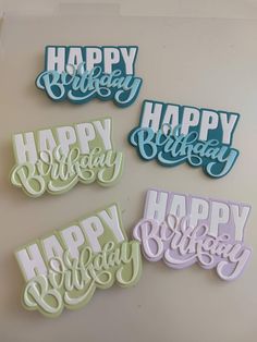 four happy birthday cutouts are displayed on a white surface with the words happy birthday spelled in blue, green and purple