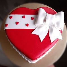 a heart shaped cake decorated with hearts and a bow