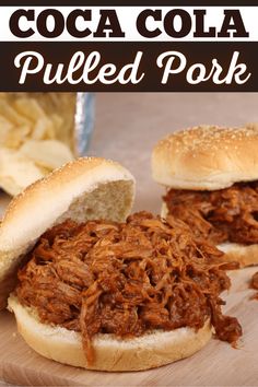 two pulled pork sandwiches sitting on top of a wooden cutting board