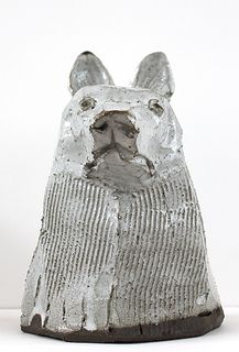 a silver dog statue sitting on top of a white table