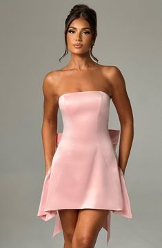 The Freja mini blush dress is party perfection. Crafted in luxurious stretch satin, this beautiful design is strapless with a corseted bodice and flirty, flouncy skirt. A dramatic bow to the back finishes the look. Strapless Corset, Popular Dresses, Blush Dresses, Stretch Satin