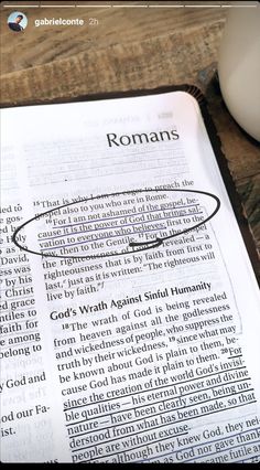 an open bible with the word romans on it and a cup of coffee next to it