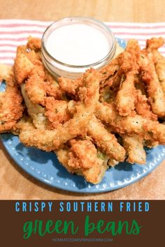 crispy southern fried green beans on a blue plate with ranch dressing in the background