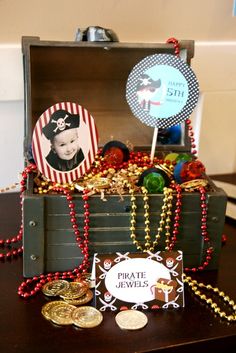 an open trunk filled with lots of gold and red beads on top of a table