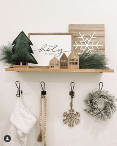 christmas decorations are hanging on the wall above a shelf with a sign and snowflakes