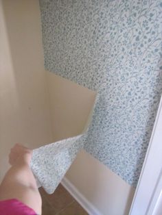 a person with a towel on their head in front of a wallpapered room