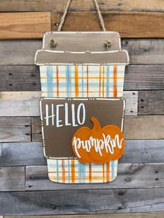 a handbag hanging on a wooden wall that says hello pumpkin