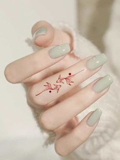 a woman's hand with some nail polish on it and a red flower painted on the tip of her finger