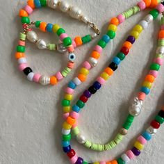 a multicolored beaded necklace on a white surface