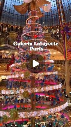 a christmas tree in the middle of a shopping mall with lights and decorations on it