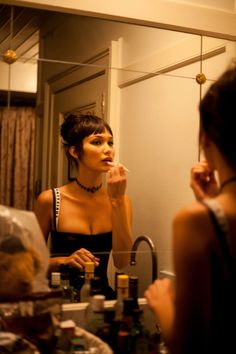 a woman brushing her teeth in front of a mirror