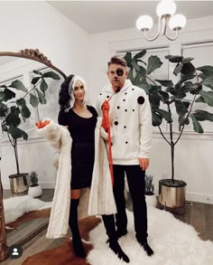 a man and woman dressed up for halloween standing in front of a mirror with fake leaves on it