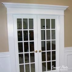 an empty room with two white french doors