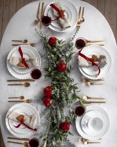 the table is set with plates, silverware and red rose centerpieces for an elegant valentine's day meal