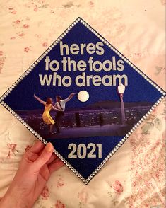 someone is holding up a graduation cap that says heres to the fools who dream