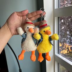 two stuffed ducks are hanging from a keychain