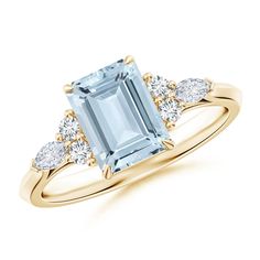 an aqua blue topazte and diamond ring with three diamonds on the side, in yellow gold