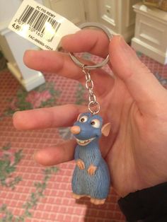 a hand holding a small toy animal keychain