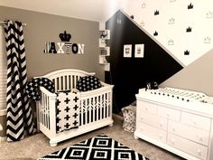 a baby's room with black, white and gray decor on the walls is shown