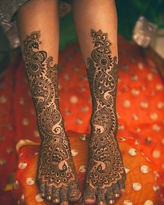 the legs and feet of a woman with henna tattoos