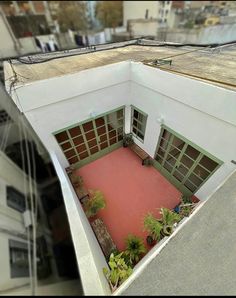 an aerial view of a building with red carpet and plants on the ground below it