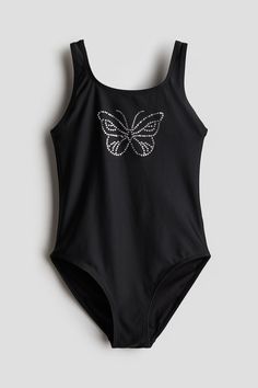 Fully lined swimsuit with a motif at front in rhinestones. Round  low-cut neckline at front and a low-cut back. Cute Bathing Suits For Kids 10-12 Black, Cute Bathing Suits For Kids 10-12 2 Peice, Bathing Suits For Kids 11-12, Swimsuits For Girls 10-12, Cute One Piece Bathing Suits, Black Cutout One-piece Swimsuit For Beach, Cute One Piece, One Piece Bathing Suits, Butterfly Kids