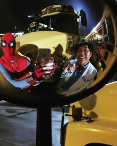 a man is taking a selfie in front of a school bus with his cell phone