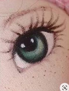 an image of a woman's eye with green eyeshade and long eyelashes