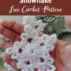 a hand is holding a crocheted snowflake ornament