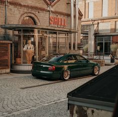 a green car parked in front of a store