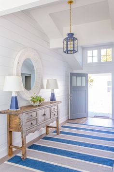 a blue and white striped rug in a room with two lamps on either side of the table