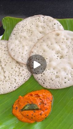 two flat breads on a green leaf with an orange sauce in the middle and another piece of bread sitting next to it